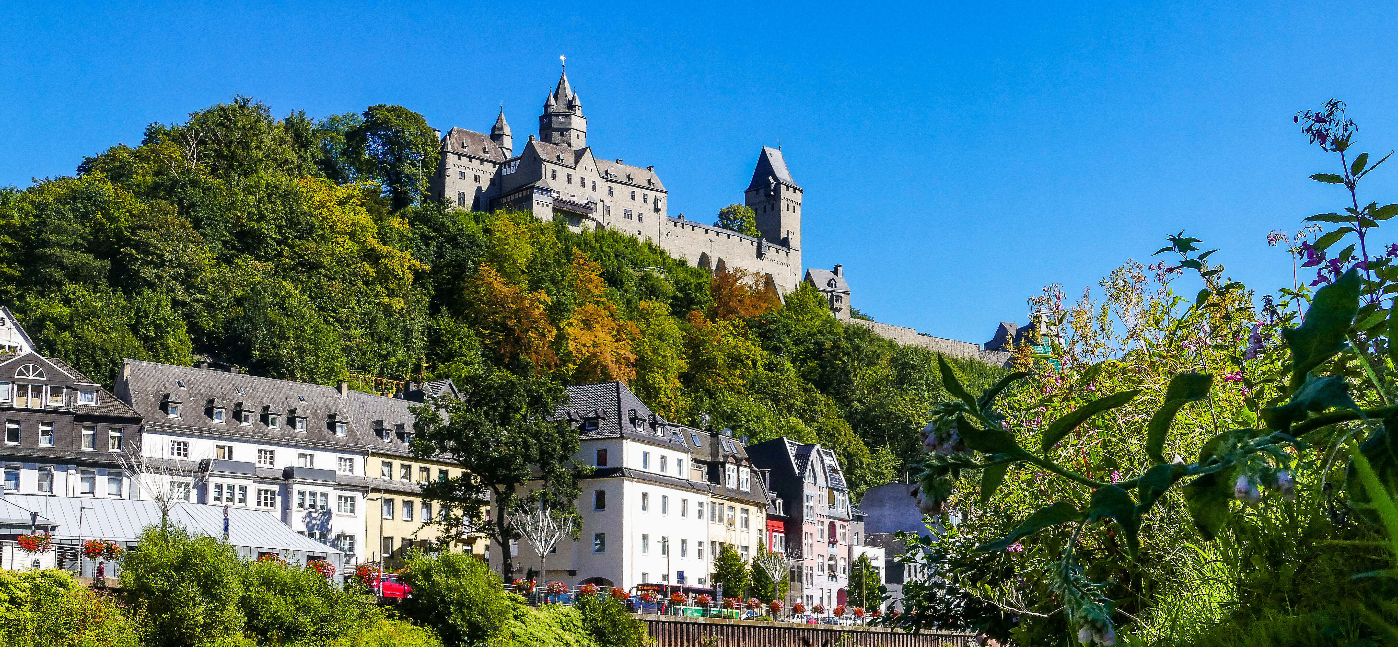 Hinter dem Fluss Lenne liegt die Innenstadt Altenas und die Burg Altena 